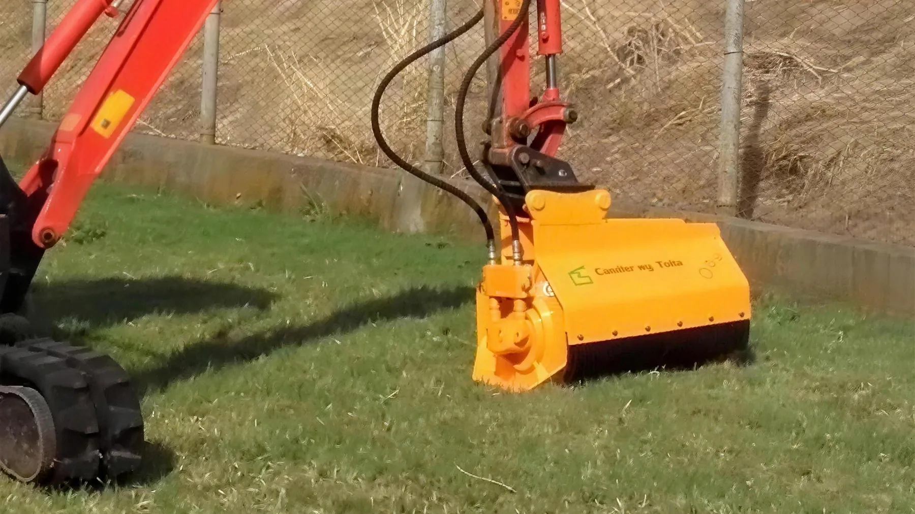 Minibagger mit Mulcher-Anbaugerät im Grünland